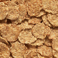A close-up, top-down view of golden-brown cornflake cereal pieces piled together, filling the entire frame.