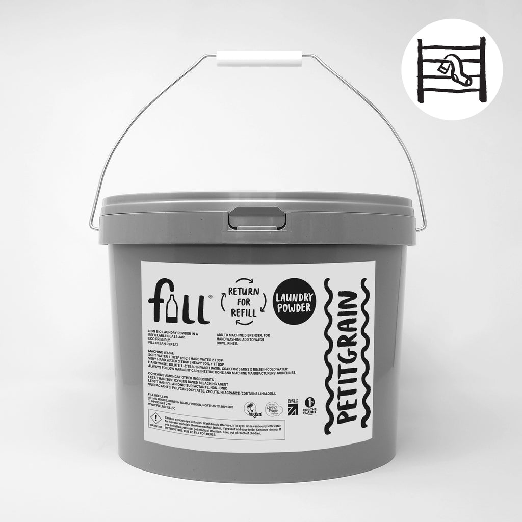 A gray plastic bucket of full refill laundry powder with a white handle, featuring a white label with black text. A small circular diagram in the top right shows the refill process.