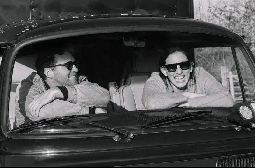 Melissa & Sam (The Refill Barn Owners) sat in a vintage VW truck, laughing. 