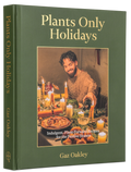The front and spine of the book 'Plants Only Holidays' by Gaz Oakley, featuring a dark olive green cover with gold lettering and a central photograph of a man cooking at a candlelit table.
