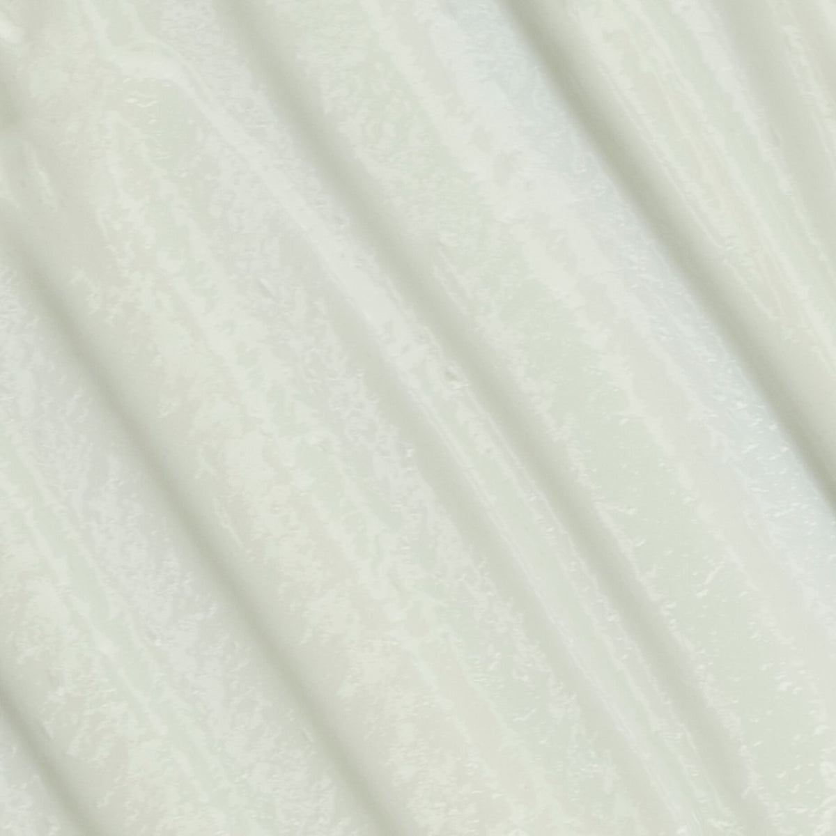 A close-up texture shot of a cream-colored fabric with a subtle, fine woven pattern and soft diagonal folds.