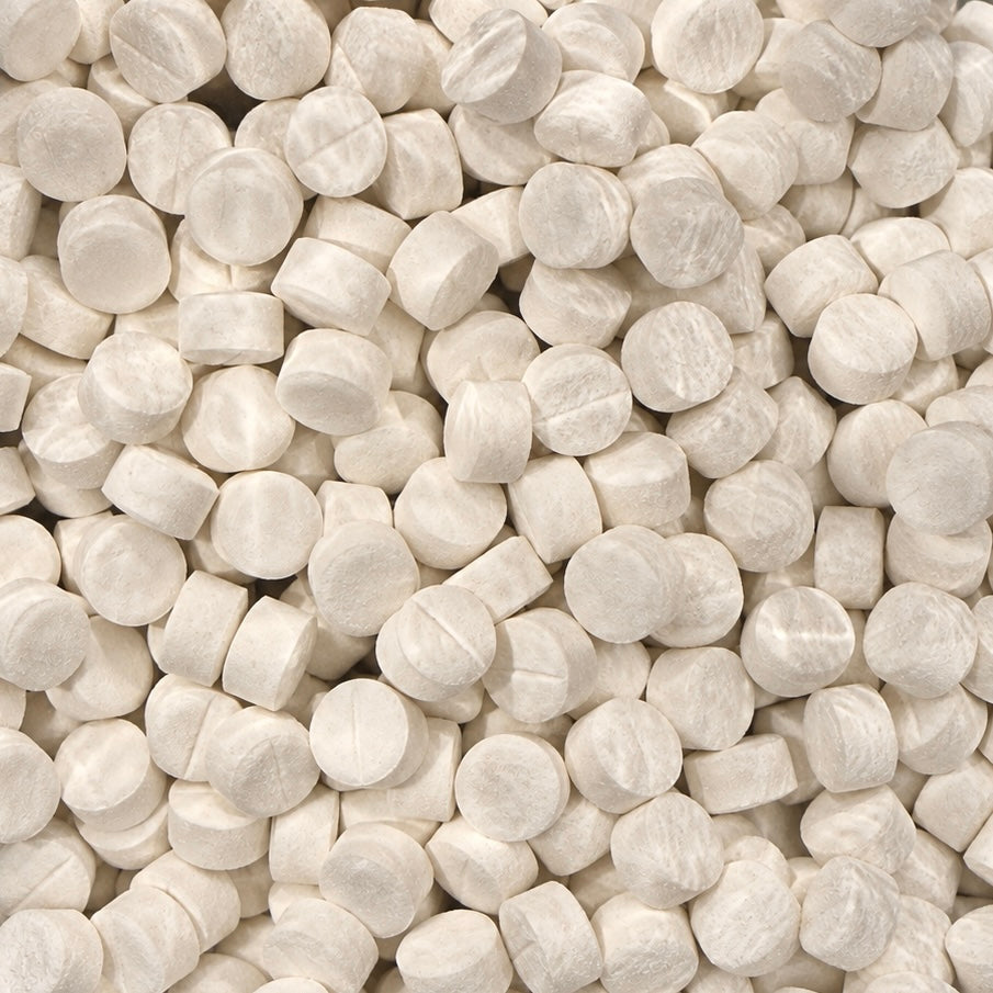 A close-up pile of round, off-white tablets or pills filling the frame.