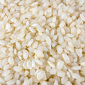 A large mound of short grain white rice fills the frame in this close-up shot. 