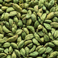 A close-up, top-down view of numerous green cardamom pods filling the entire frame.