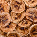 This enticing close-up showcases a cluster of dried banana chips. Each chip features a distinct brown center with radial lines, surrounded by a lighter, tan exterior. 
