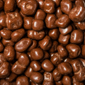 A close-up, top-down view of glossy chocolate-covered ginger filling the entire frame.