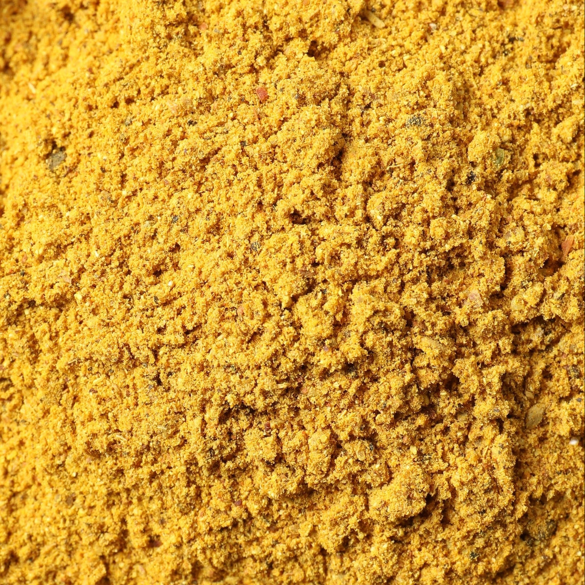 Bright yellow curry powder, filling the entire frame. 