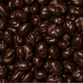 A close-up textured shot of dark chocolate-coated peanuts, filling the entire frame. 