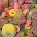 Close-up image of fizzy gummy sweets of various shapes/sizes filling the frame.
