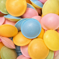 A close-up pile of Flying Saucers in yellow, pink, blue, and light green.