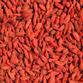A vibrant close-up photograph showcases a rich collection of dried goji berries. The berries fill the frame, creating an organic red pattern.
