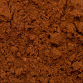 A close-up view of a mound of fine brown powder with a textured, crumbly surface.