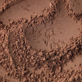 This close-up captures the rich, textured surface of cocoa powder, creating an abstract and organic visual.