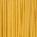 An abstract close-up of uncooked linguine pasta filling the entire frame. 