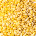 A pile of yellow dal beans on a plain white background.