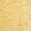 A top-down view of a light yellow texture powder filling the entire frame. 