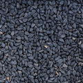 A close-up, top-down view of a dense pile of black seeds, filling the entire frame.