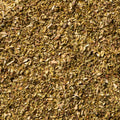 A close-up texture shot of dried, finely chopped oregano filling the entire frame. 