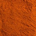 A close-up texture shot of a fine, granular paprika spice, filling the entire frame.