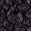 A detailed close-up showcases a generous pile of dried pitted Prunes