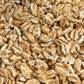 A close-up, top-down view of golden-brown popcorn kernels piled together, filling the entire frame.