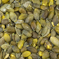 A close up overhead shot shows a pile of hulled pumpkin seeds. 