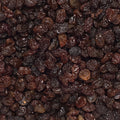 This tightly framed close-up captures a heap of plump, shiny brown raisins, showcasing their wrinkly texture.