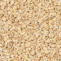A close-up, top-down view of raw rolled oats filling the entire frame.