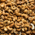 This extreme close-up photograph showcases a heap of salted cashew nuts. 