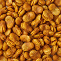 A close-up, top-down view of seasoned roasted fava beans, showing their golden-brown color and textured coating.