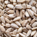 An eye-level close-up shot showcases a multitude of peeled sunflower seeds.