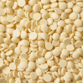 A close up of a pile of white chocolate drops, filling the entire frame.