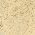 A close-up of a light beige powder filling the entire frame. 