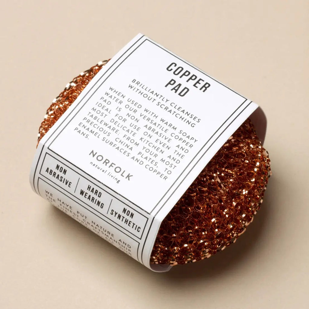 Copper pad with a label on a beige background